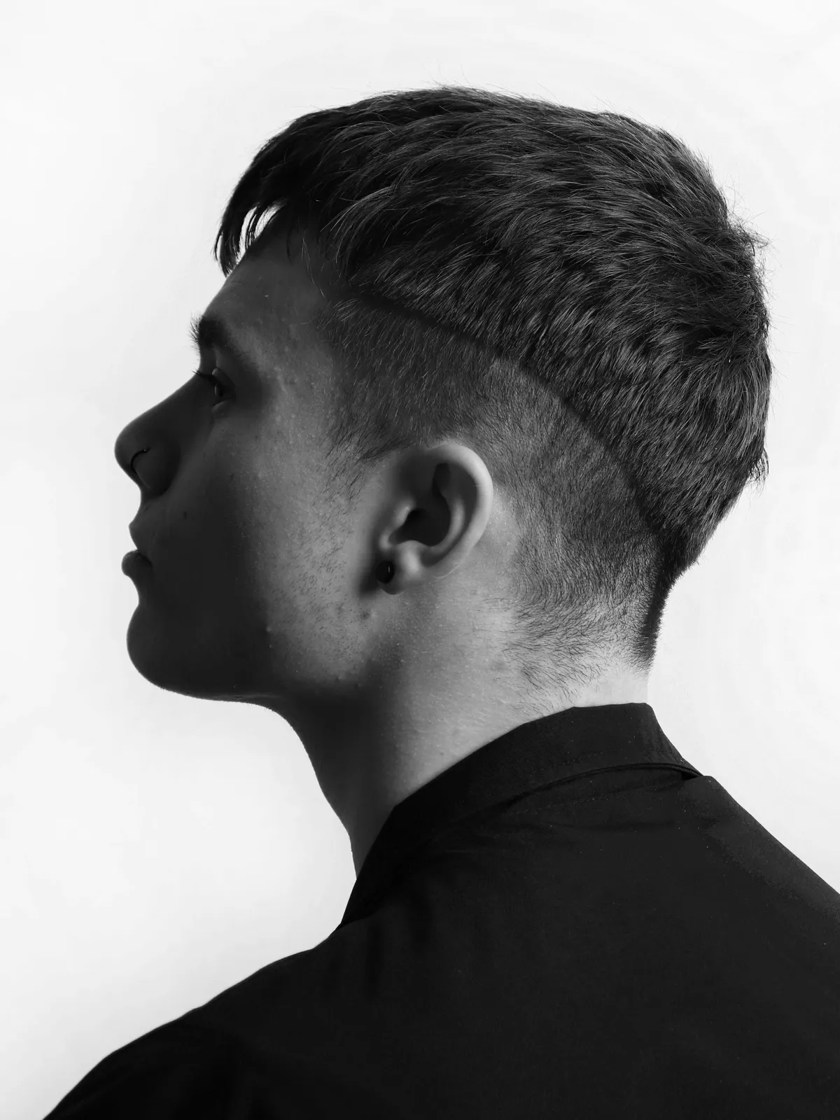 Schwarz-Weiß-Profil eines jungen Mannes mit kurzem Schnitt