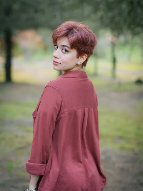 Frau mit kurzen, rosé-roten Haaren im Freien