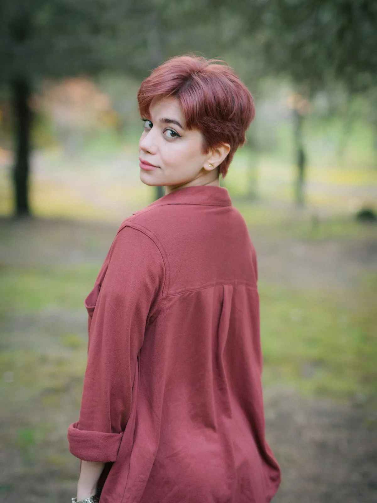 Frau mit kurzen, rosé-roten Haaren im Freien